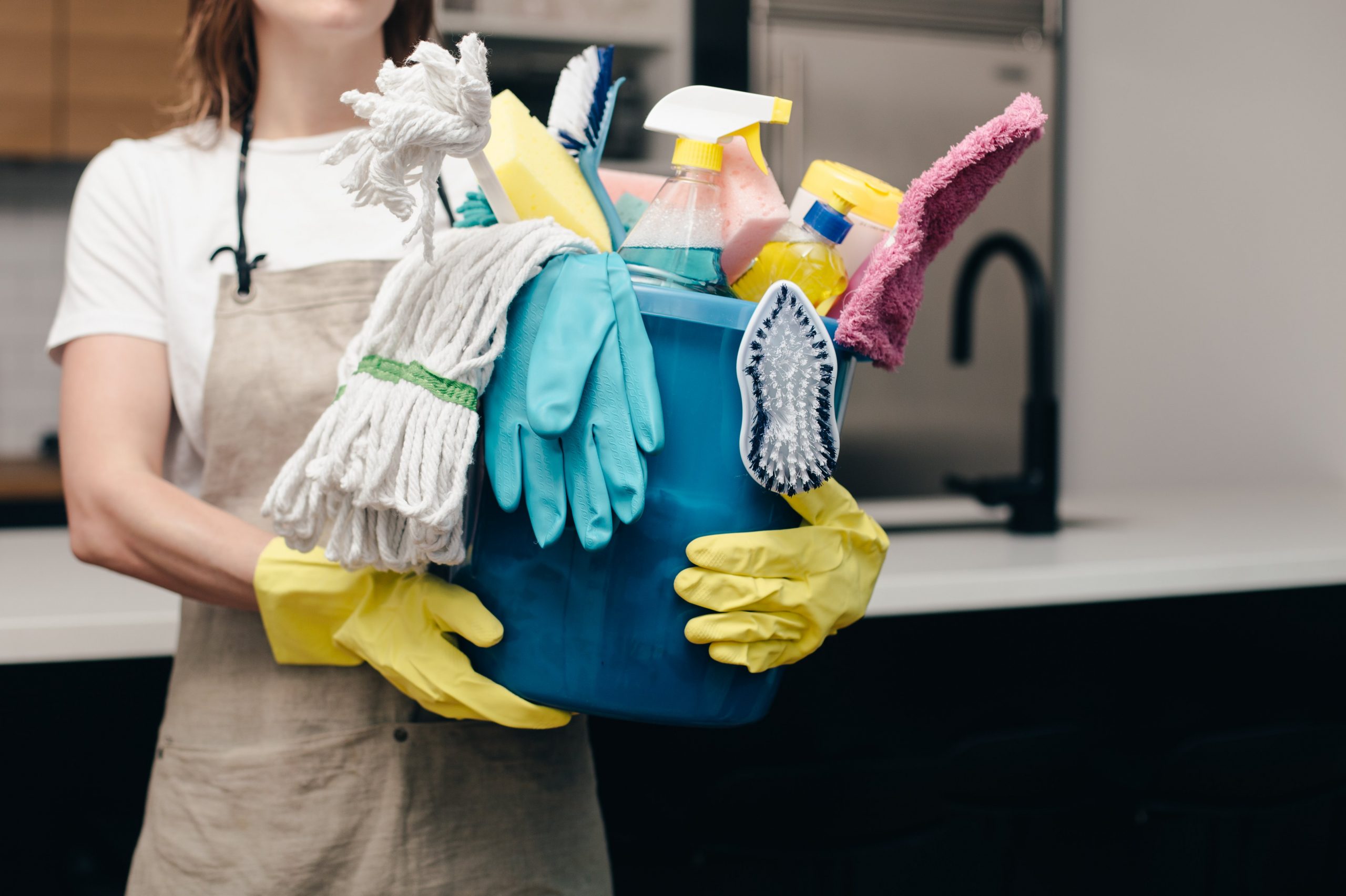 woman holds cleaning supplies